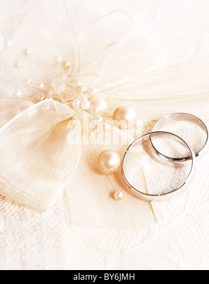 Paar goldene Hochzeit Ringe über Einladungskarte mit Seidenschleife & Perlen verziert Stockfoto