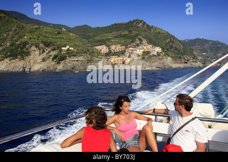 Familie auf Ausflugsschiff, Blick vom Meer nach Manarola, Bootsfahrt entlang der Küste, Cinque Terre, Ligurien, italienische Riviera, Stockfoto