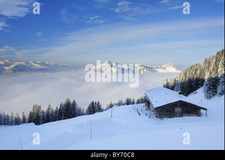 Verschneite Almhütte mit Karwendel, Wetterstein und Tegernsee Bergkette im Hintergrund, Rotwand, Spitzing Bereich Bava Stockfoto