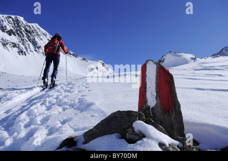 Rock mit Marker, Frau Skitouren außerhalb des Fokus im Bereich Hintergrund, Staller Sattel, Villgratner Berge, Südtirol, Stockfoto