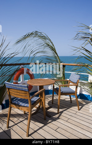 Palmwedel am Geländer und Liegestühlen und Tisch an Bord Kreuzfahrtschiff MS Delphin (Hansa Kreuzfahrten), Karibik Stockfoto