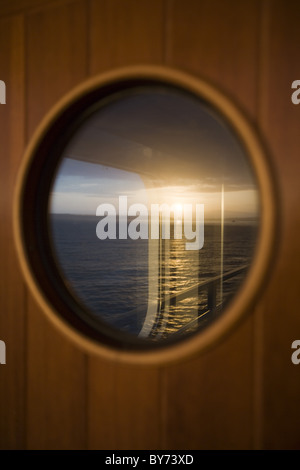 Sunrise-Reflexion über Fenster Kreuzfahrtschiff Silver Spirit, Atlantik, Europa Stockfoto