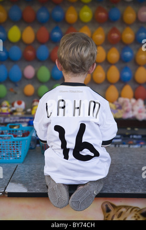 Kleiner Junge mit einem Phillip Lahm Deutsch National Soccer Teamtrikot an einem Dart-Stand auf einer Kirmes, Rotenburg eine der Fulda, Hessen, Stockfoto