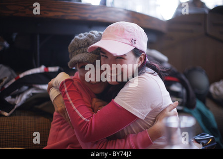 Zwei Frauen umarmen einander, Apres-Ski bar, Whistler, British Columbia, Kanada Stockfoto