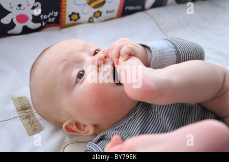 Baby spielt mit seinem Fuß Stockfoto