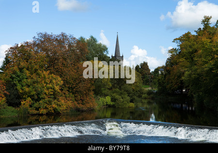 Entfernte Saint Pauls Kirchturm und Wehr auf dem Fluss Suir, Caher, County Tipperary, Irland Stockfoto