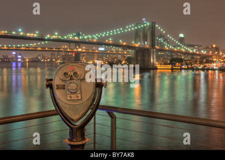 Ein Blick vom South Street Seaport der Brooklyn und Manhattan Brücken am East River in New York City in der Nacht. Stockfoto
