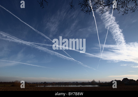 Kondensstreifen oder Dampfpfade sind Kondensstreifen und künstliche Zirruswolken, blauer Himmel über Lincolnshire, mehrere Wanderwege. Stockfoto