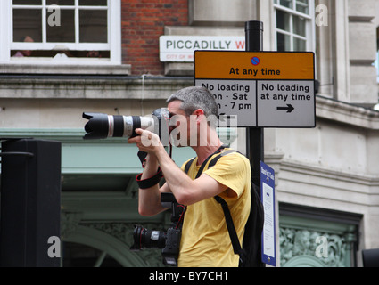 Ein Fotograf bei der Arbeit fotografiert eine Demonstration in London, England, Vereinigtes Königreich Stockfoto