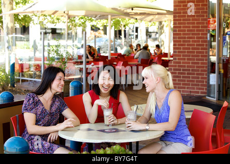 Australische Mädchen im Chat über einen Eiskaffee in einem Stadt-Café im Freien, in Adelaide, South Australia im Sommer Stockfoto