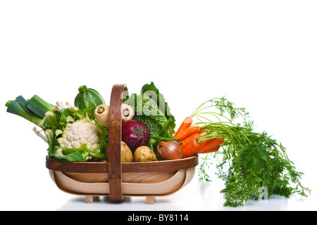 Foto von einem hölzernen Trug voll von Bio-Gemüse, isoliert auf einem weißen Hintergrund. Stockfoto