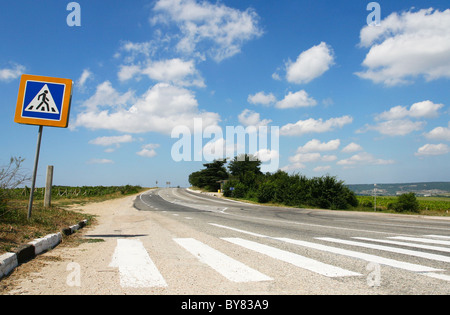 Fußgängerübergang mit einem Schild auf einer Landstraße Stockfoto