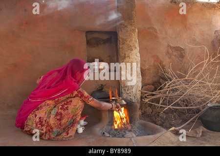 Indien, Rajasthan, Jodhpur, Frau in Tracht, kochendes Wasser auf offenem Feuer Stockfoto