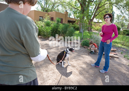 Elfjähriger Junge lernen, seinen Hund zu trainieren, Leine, während Hundetrainer weist ihn auf das, was als nächstes zu tun. Stockfoto