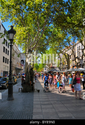 Touristen und Einheimische gleichermaßen genießen im schützenden Schatten der Bäume auf La Rambla (Abschnitt Rambla de Santa Mònica), Barcelona, Spanien. Stockfoto