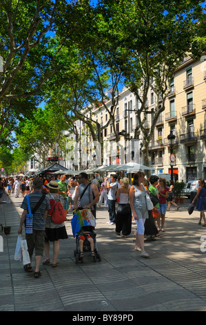 Touristen und Einheimische gleichermaßen genießen im schützenden Schatten der Bäume auf La Rambla (Abschnitt Rambla de Santa Mònica), Barcelona, Spanien. Stockfoto