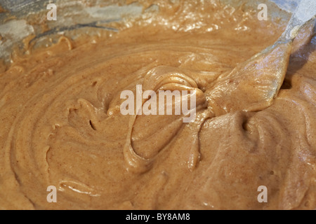 Verbreitung von Teig in gefettete Backpapier ausgekleidet runden Sandwich-Backform Stockfoto