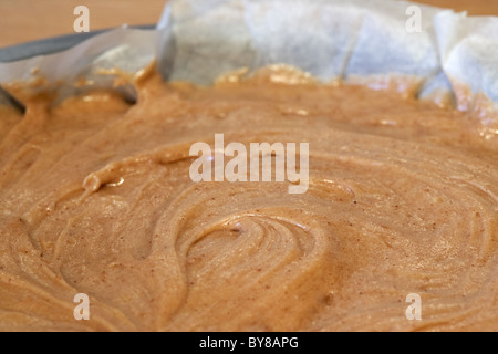 Teig in gefettete Backpapier ausbreiten ausgekleidet runden Sandwich-Backform Stockfoto