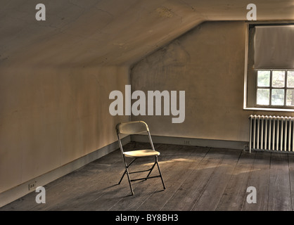 Einsame Stuhl sitzt In vernachlässigten leeren Raum Stockfoto