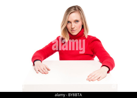 Junge Frau, Büroangestellter oder Student an lustigen kleinen Schreibtisch sitzen. Studio Foto, isoliert. Stockfoto