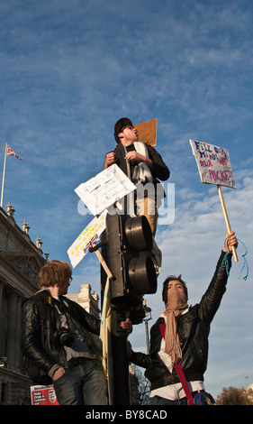 Studentischen Demonstranten Klettern auf Ampeln mit Plakaten während Gebühren Studentenproteste im Parlament Square London 12.09.2010 Stockfoto