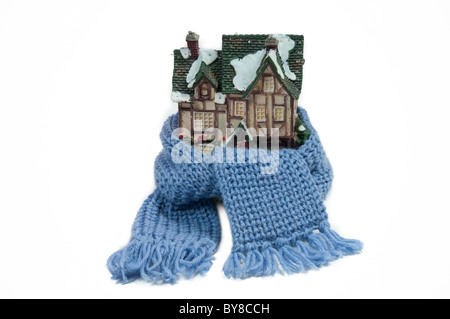 Weihnachten Spielzeug Haus eingehüllt in eine blaue handgemachte Schal isoliert - konzeptuelle Ansicht zu schützen oder zu isolieren Haus Stockfoto