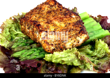 köstlichen gegrillten Wolfsbarsch, gewürzt mit feinen Gewürzen mit Spargel und Salat-Bett Stockfoto