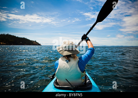 Eine Rückansicht einer Frau in einem Kajak paddeln, auf der geraden Haro aus San Juan Island, WA, USA. Stockfoto