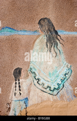 Ein Gemälde auf einer Adobe-Wand eines indianischen Mutter und Tochter finden Sie im La Luz, New Mexico. Stockfoto