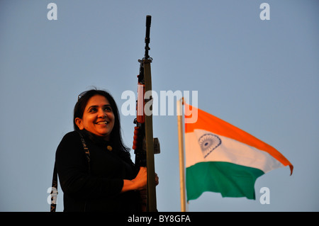 Patrioltic Inderin mit einer Pistole und Tri Color indische Nationalflagge im Hintergrund Stockfoto