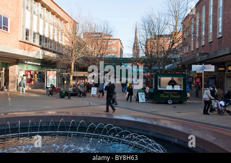 Der Bezirk Shopping Centre in zentralen Coventry mit dem Turm der Kathedrale im Hintergrund, West Midlands, England. Stockfoto