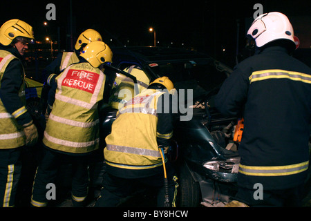 Verkehr Unfall Feuer Crewss retten gefangen Treiber Stockfoto