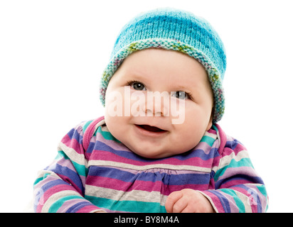 Kopf- und Schulteraufnahme eines kaukasischen Babys in einem knallbunten gestreifte Outfit und türkisfarbenem Hut Stockfoto