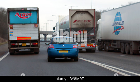 Aggressive und gefährliche Autofahrer in zusammenführen Autobahn Spur hinter LKW fahren Stockfoto