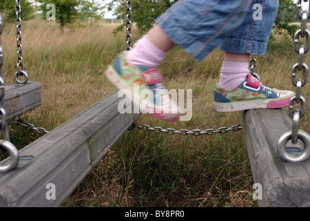 Junges Mädchen balancieren auf Kletterausrüstung Stockfoto