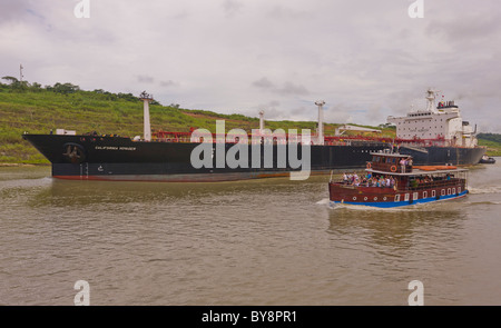 PANAMA - Touristenboot und Frachter auf Panama-Kanal. Stockfoto