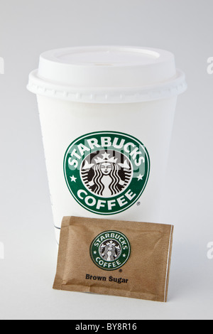 Starbucks Einweg-injektionsnadeln Papier takeaway Kaffeetasse Einsatz mit Kunststoff trinken gehen - durch Deckel und ein Päckchen von braunem Zucker. England Großbritannien Stockfoto