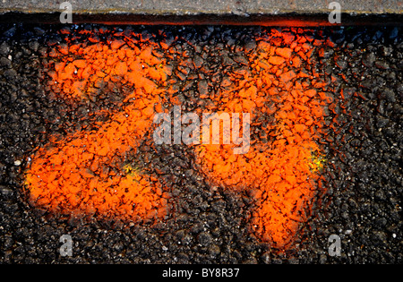 rote Zahlen auf Asphalt gesprüht Stockfoto