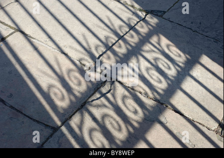 Schatten Besetzung vor Ort durch eine viktorianische dekorative Eisentor an einem sonnigen Herbsttag Stockfoto