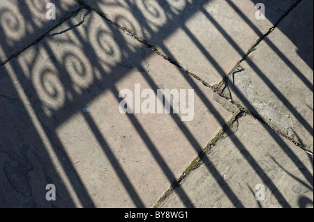 Schatten Besetzung vor Ort durch eine viktorianische dekorative Eisentor an einem sonnigen Herbsttag Stockfoto