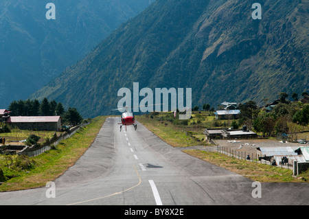 Hubschrauberlandeplätze auf der gefährlichen und winzige Lukla-Landebahn in der Everest Region Nepals Stockfoto