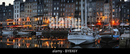 Segelboote und Touristen an Straßencafés / Bürgersteig Cafés entlang des Kais der Honfleur Hafen bei Nacht, Normandie, Frankreich Stockfoto