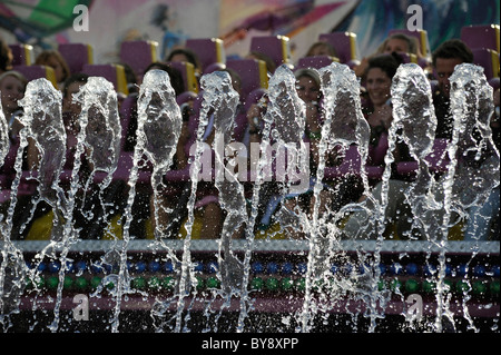 Passagiere in fahren "Top Spin" hinter Wasserspiele auf dem Oktoberfest, München, Deutschland Stockfoto