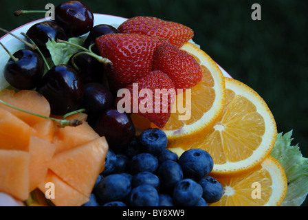 Obstteller mit Orangen, Erdbeeren, Blaubeeren, cantalope und Kirschen Stockfoto