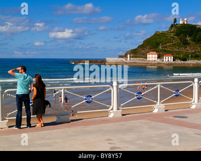 Paar auf der Suche am Strand von Ribadesella eine Stadt an der östlichen Küste von Asturien im Norden Spaniens Stockfoto