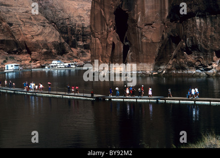 Besucher eine Tourenboot zu verlassen und Fuß über ein Schwimmdock Rainbow Bridge National Monument in Lake Powell in Arizona Zugriff auf Stockfoto