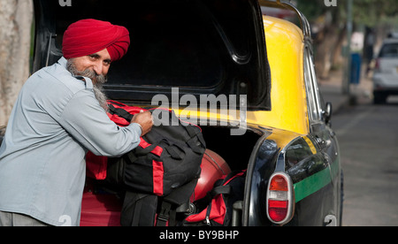 Sikh Taxifahrer laden Gepäck in die dickie Stockfoto