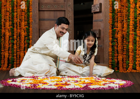 Südindische Mann und Tochter machen ein rangoli Stockfoto