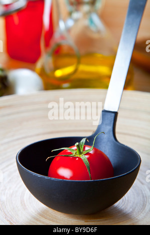 Bio Tomaten in eine Suppenkelle Stockfoto