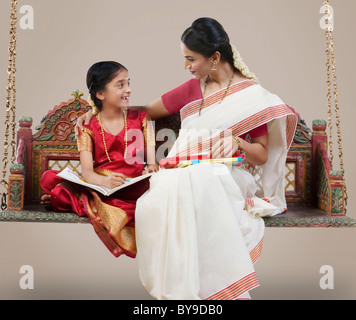 Südindische Frau sitzt mit ihrer Tochter Stockfoto